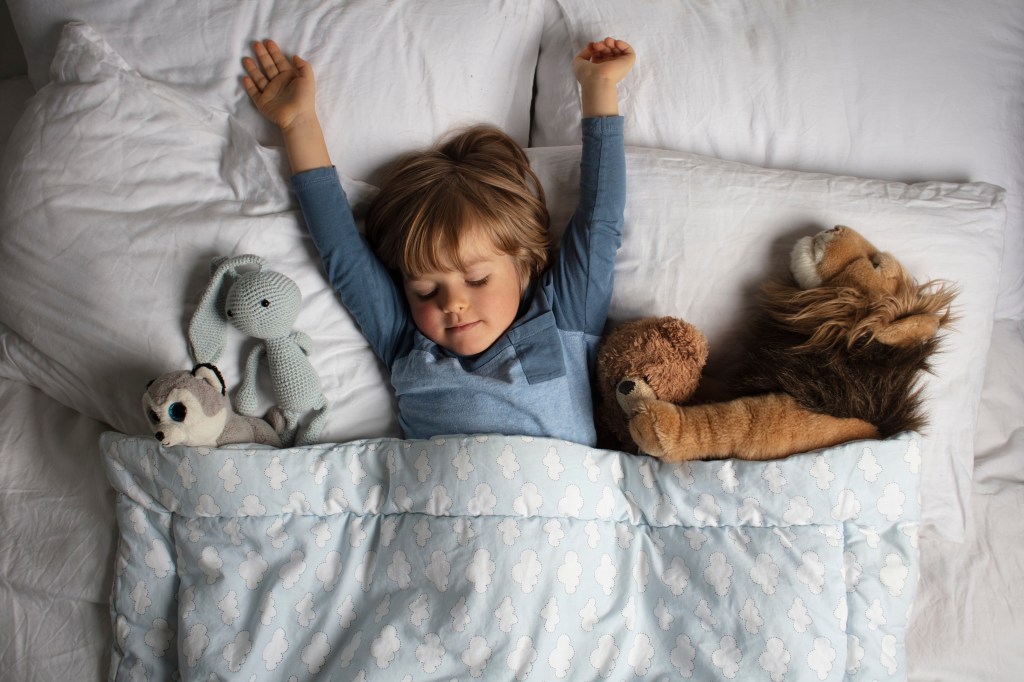 The child sleeps among stuffed animals.